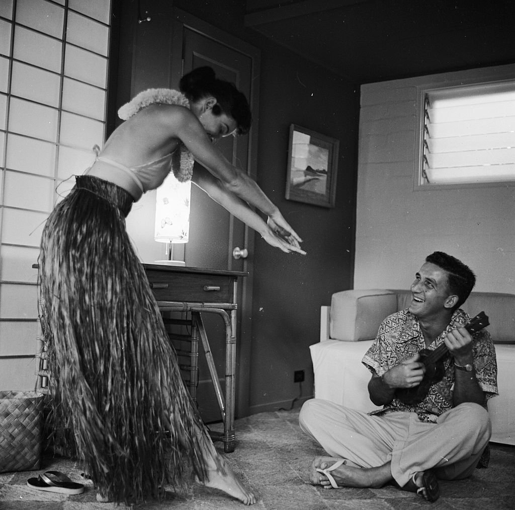 Bert and Ellie Lang, a young American couple on their honeymoon in Hawaii try a spot of hula dancing in their hotel bedroom, 1955