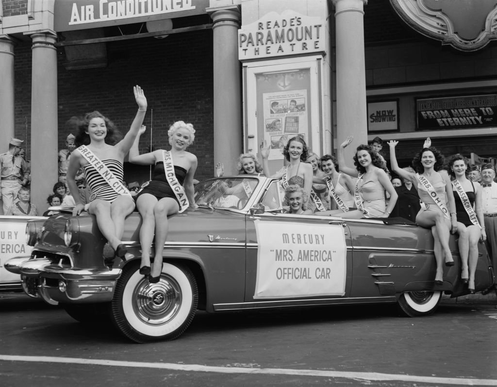 Contestants in the Mrs America 1953 pageant pose on a Mercury 'Mrs America', 1953