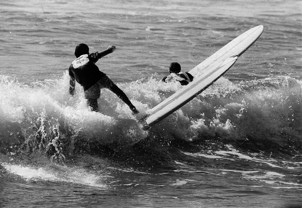 Surfers riding the waves off the coast of Hawaii, 1950