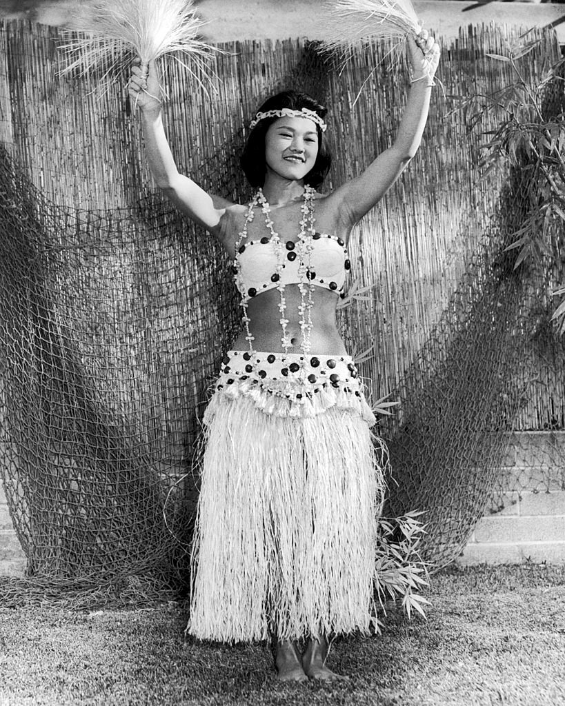 A pretty young Hawaiian woman poses in her hula skirt and dance apparel, Hawaii, 1950.