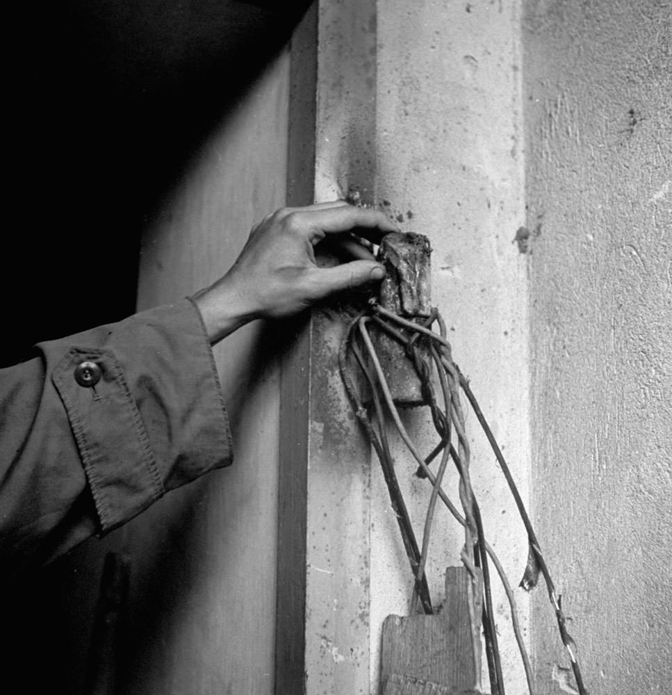 An unidentified hand on the destroyed hinge of the door to Hitler's bunker, burned off by advancing Russian combat engineers, Berlin, 1945.