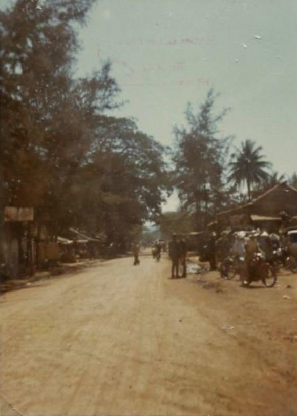 Looking out down the dirt Highway 1 through the city of Bồng Sơn in South Vietnam during the Vietnam War