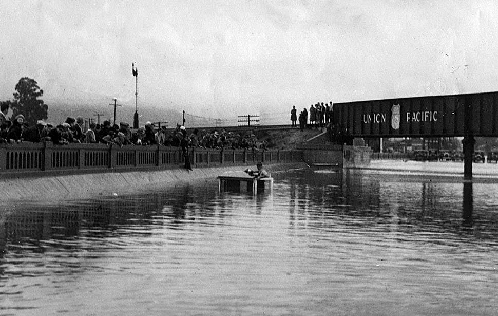 A milk truck is almost completely submerged on Whittier Boulevard under a Union Pacific railroad bridge, 1934