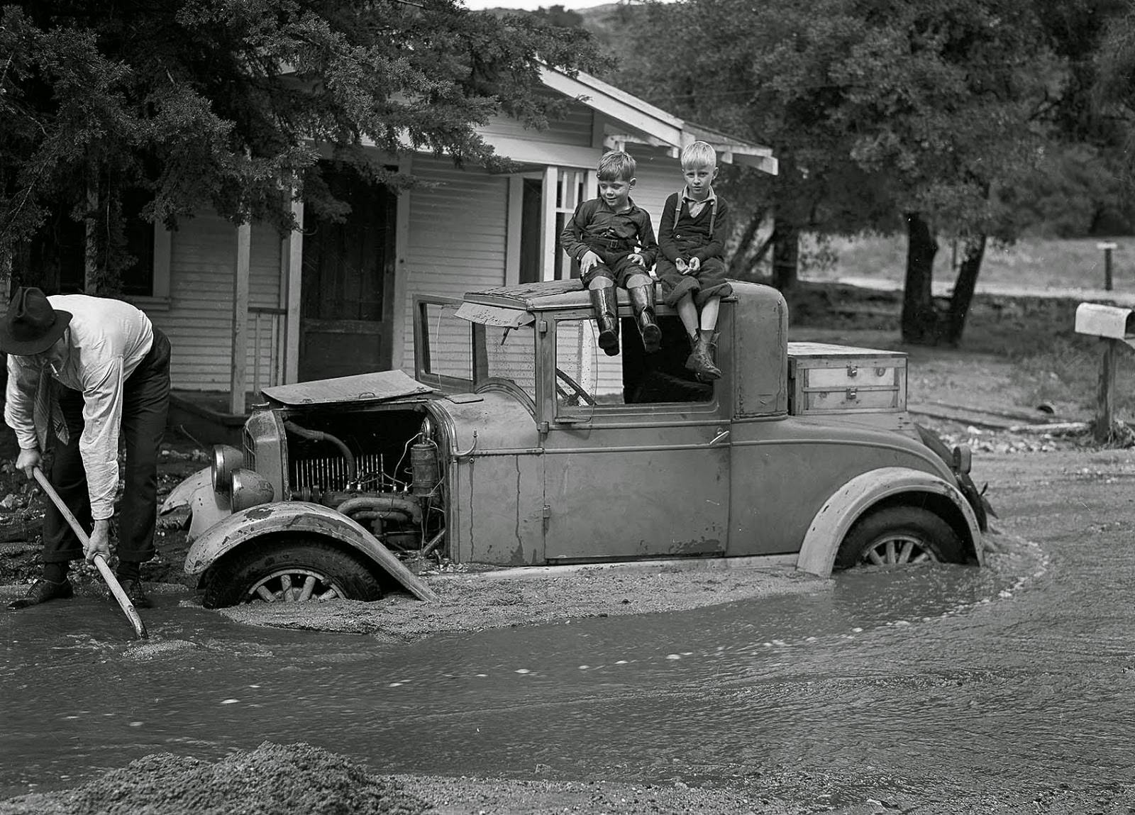 William L. Griffin digs out the family car on the 1700 block of Fernlane Street as Lloyd Griffin and David Stagg watch, 1938