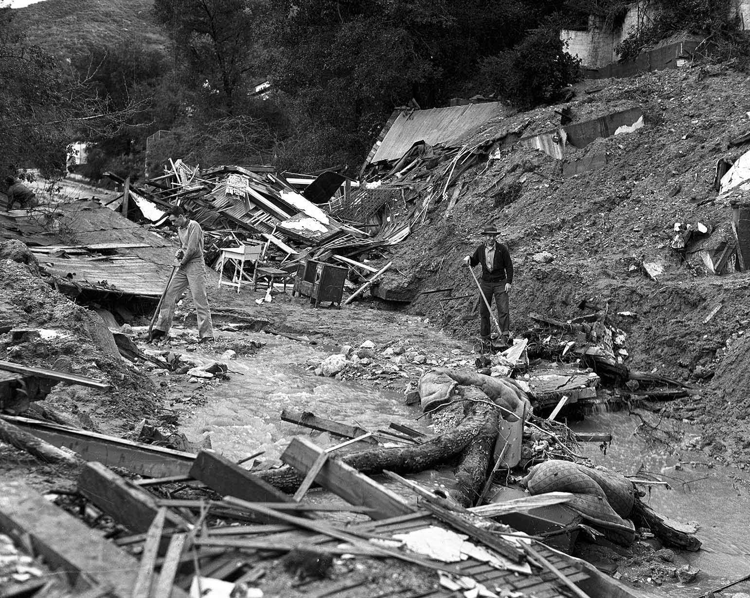 These ruins were once a residence on the 2000 block of Los Encinos Street, Glendale. Two men met their death when the house collapsed into the street. Workmen search for the bodies, 1938