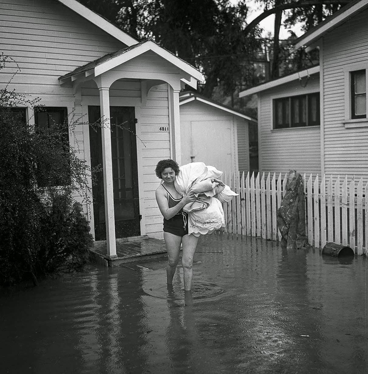 Mrs. L. Swink put on her swimsuit as she moved out after flooding, 1938