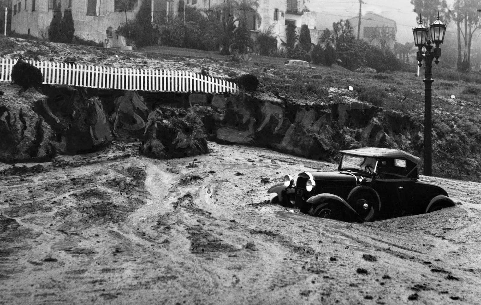 A mudslide at Harper Avenue and Sunset Boulevard caught this automobile and closed the area to traffic, 1938