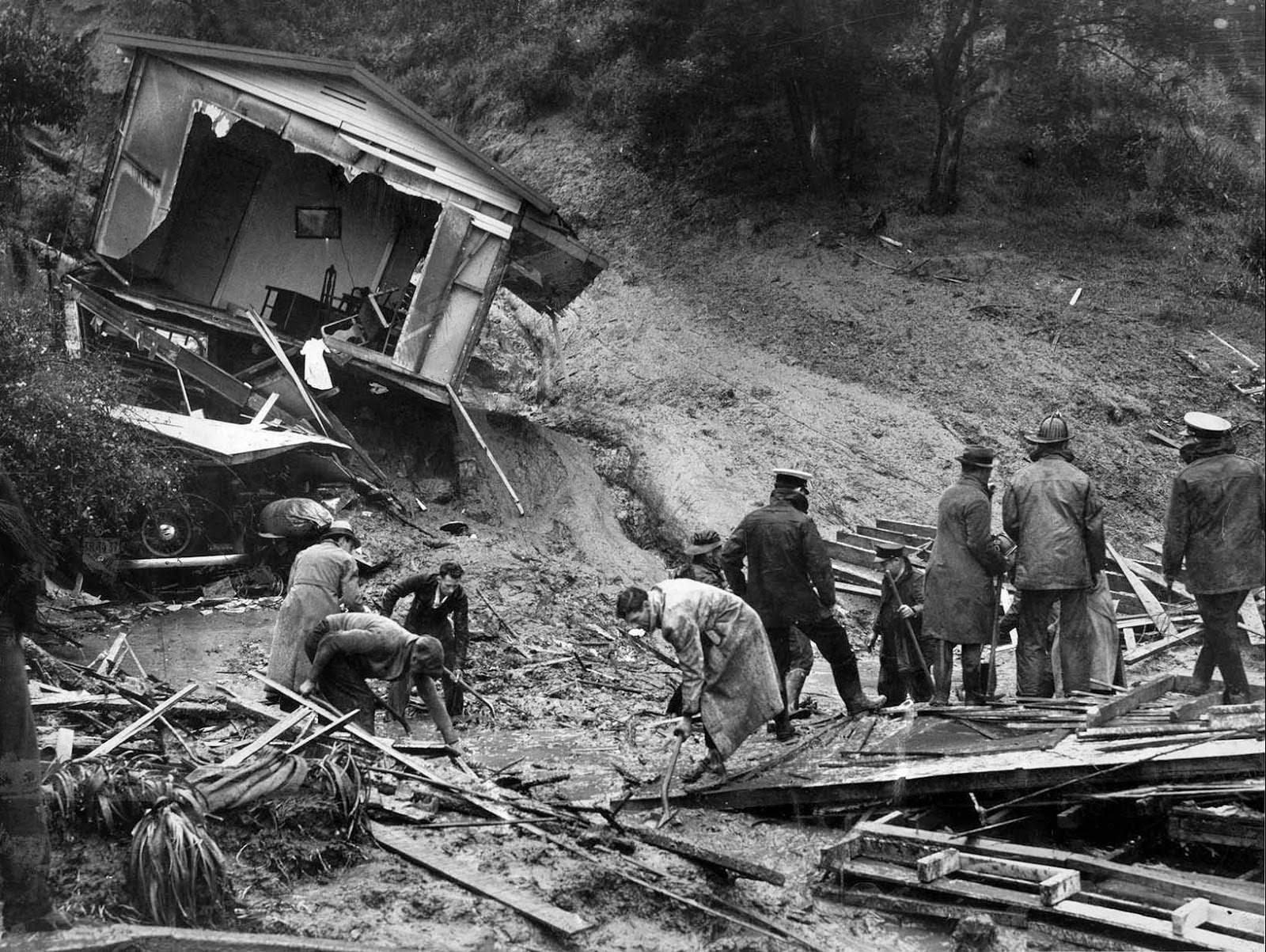 Firemen search for the body of Ruth Randall, 28, and son Leonard, 6, after their home was destroyed by a landslide on the 1900 block of Landa Street, 1938