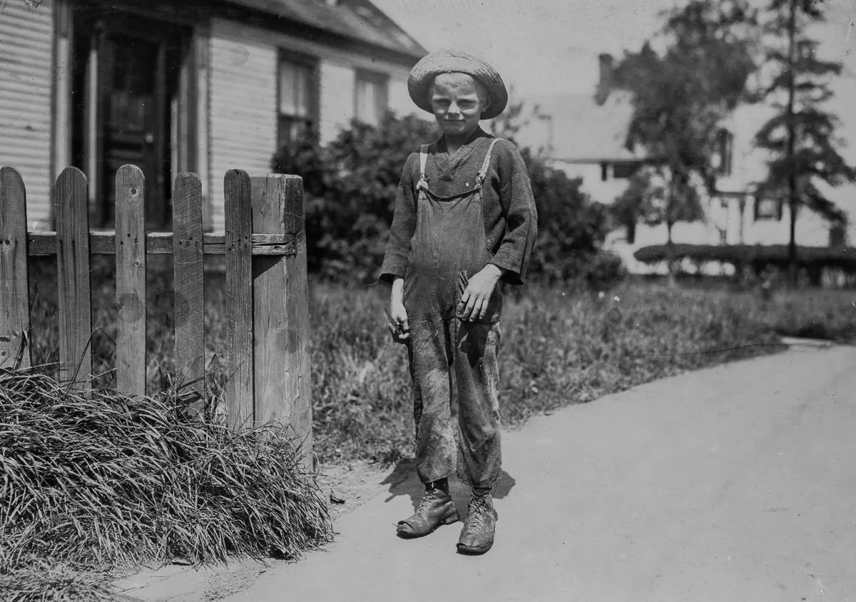 Wilfred Clark, 10 years old, going home at noon, after cutting five boxes of fish during the morning.