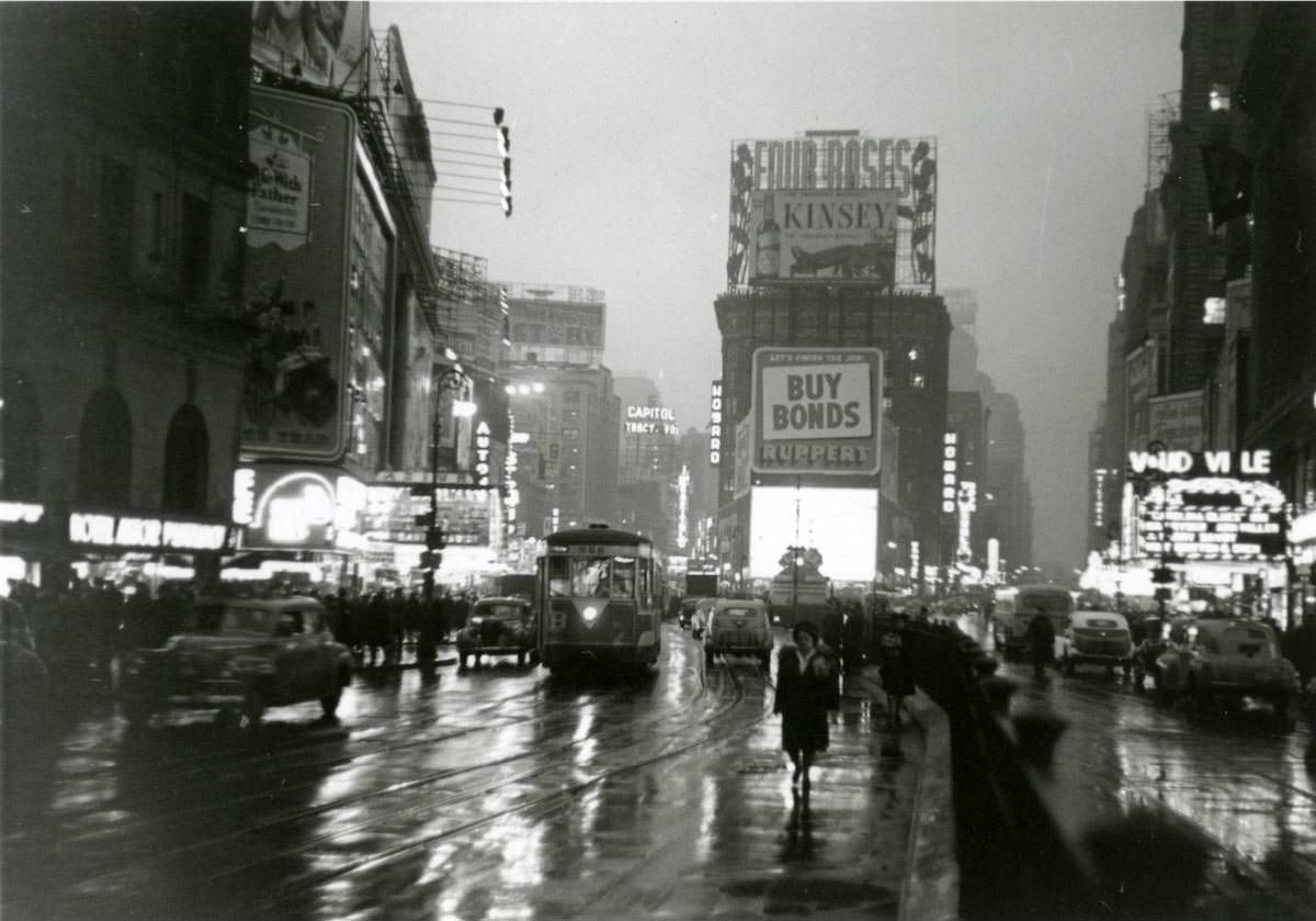 Times Square at dusk in the rain at the intersection of Broadway and Seventh Avenue at 46th Street.