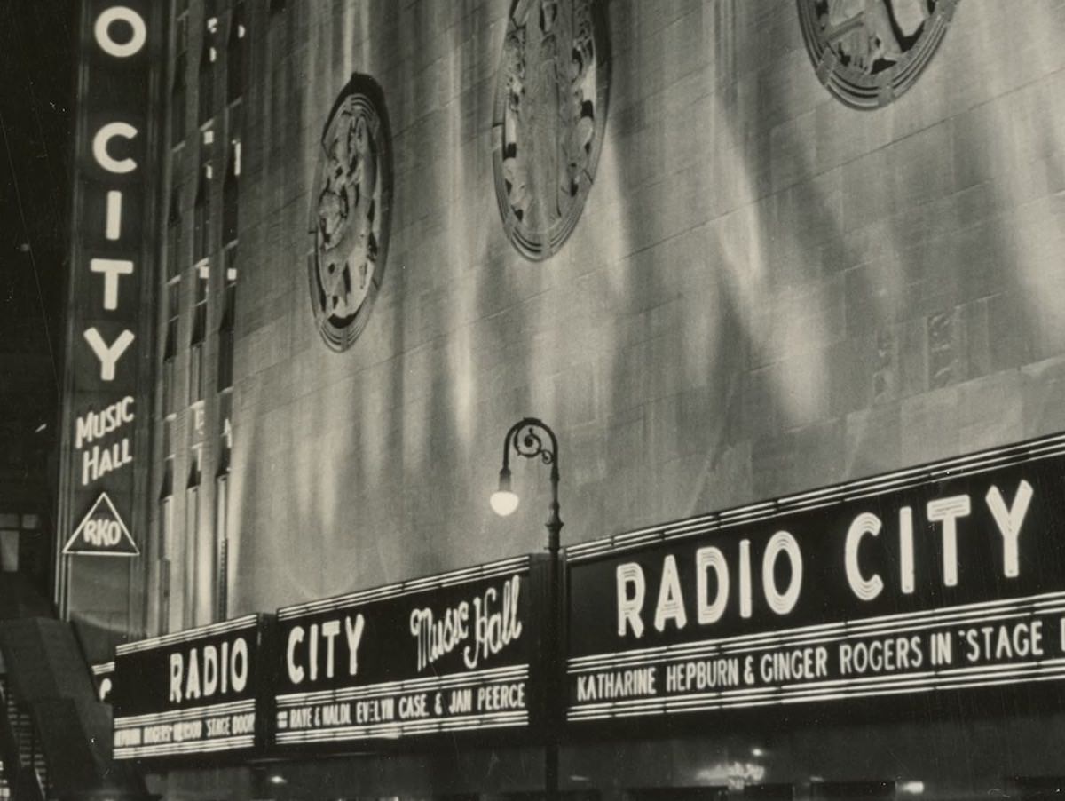 Radio City Music Hall at night. 6th Avenue El station at left. (about 1939)