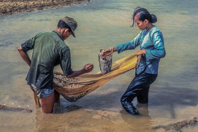 ARVN soldier and his wife gleening the last fish from the drying rain ponds by the Binh Duc air strip west of My Tho