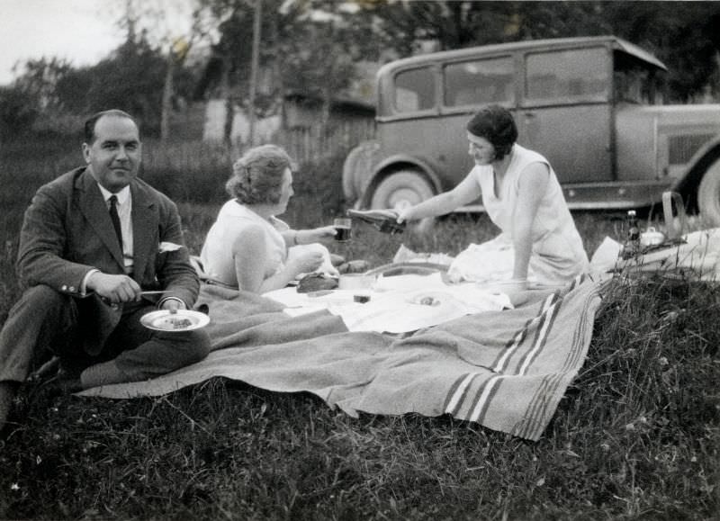 A company of three enjoying a picnic in the countryside, 1931