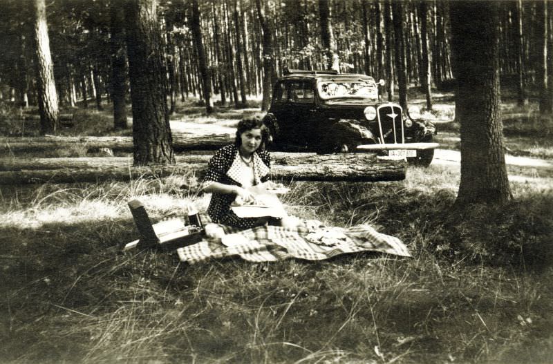 A young lady in a polka dot dress enjoying a picnic in the woods, 1938
