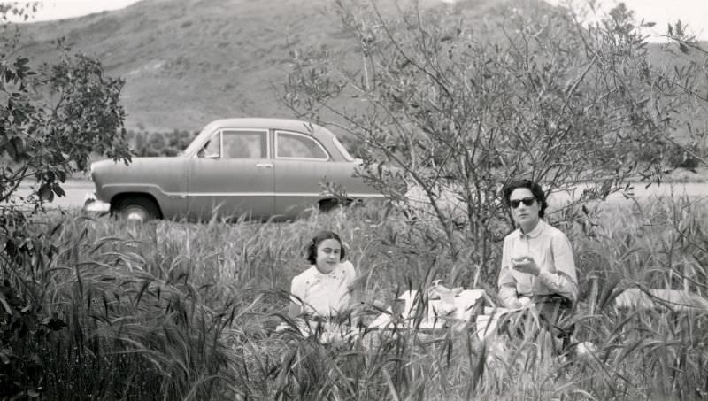 A mother and her daughter enjoying a roadside picnic in the countryside, 1954