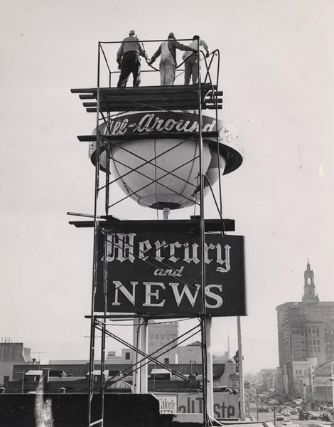 Three men on top of the Mercury and News tower looking down on First Street, San Jose, 1965