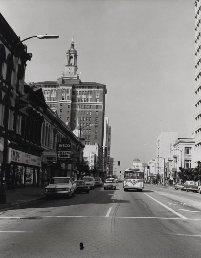 San Jose Street featuring Bank of the West, Bank of America, Disco Inferno 200, Hotel De Anza, American Savings Bus and traffic, 1970