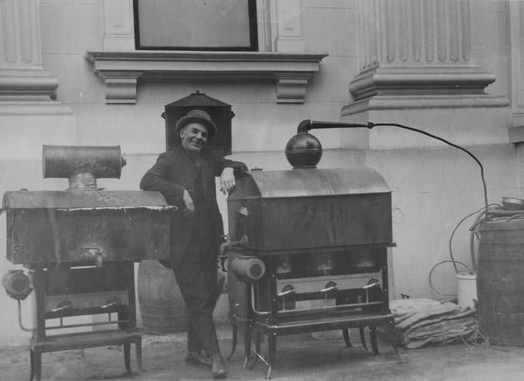 Man posing with two confiscated stills, 1925