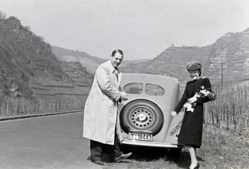 A cheerful couple posing with a Steyr 220 Limousine on a country road in the Ahr Valley, a wine-growing region south of the city of Bonn, in early spring, 1938