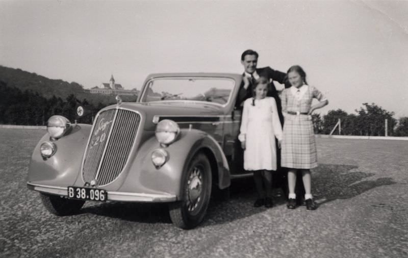 A father posing with his two daughters and a Steyr 220 Cabriolet, 1938