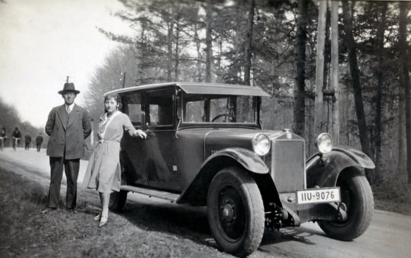 A fellow wearing a three-piece suit and an elegant lady in a knee-length dress posing with a Steyr XII saloon in the countryside, 1928