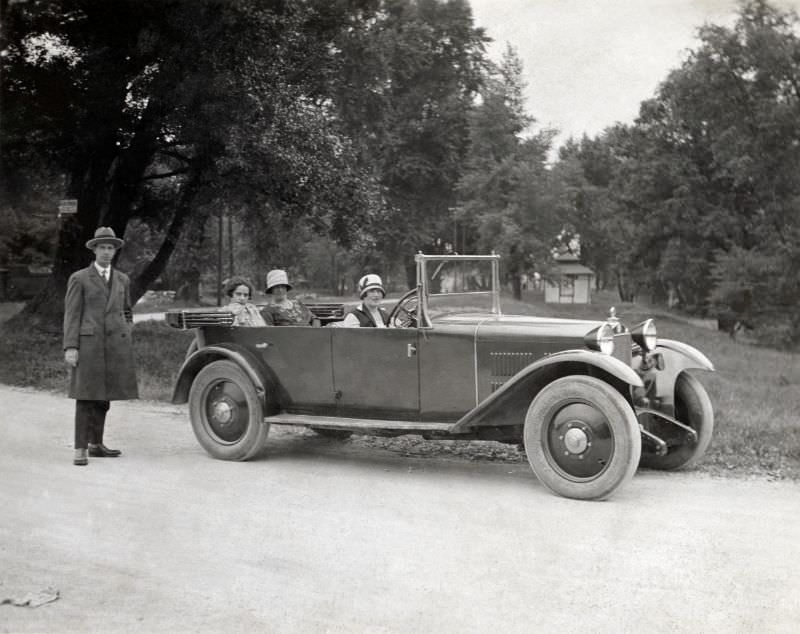 Four members of an Austrian middle-class family posing with a Steyr XII in a park or landscape garden, 1928