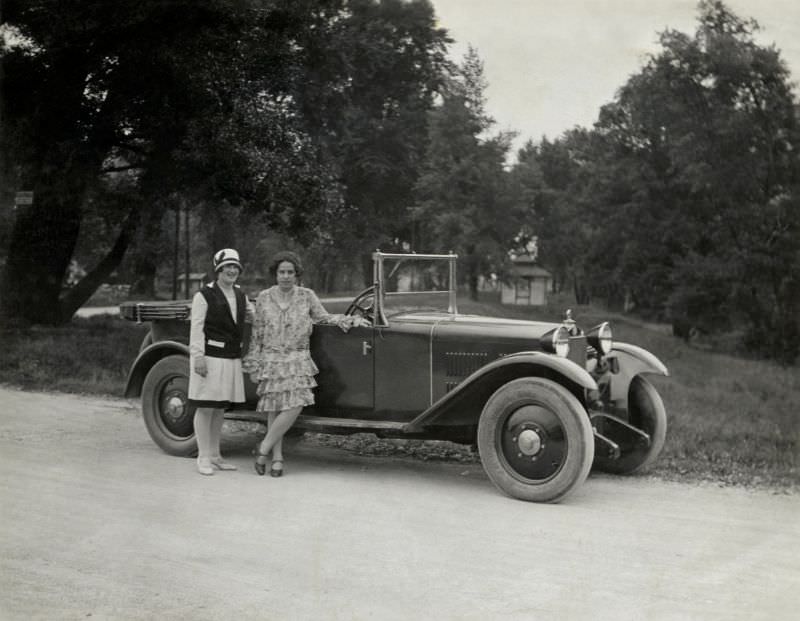 Two fashionable ladies posing with a Steyr XII in a park or landscape garden, 1928