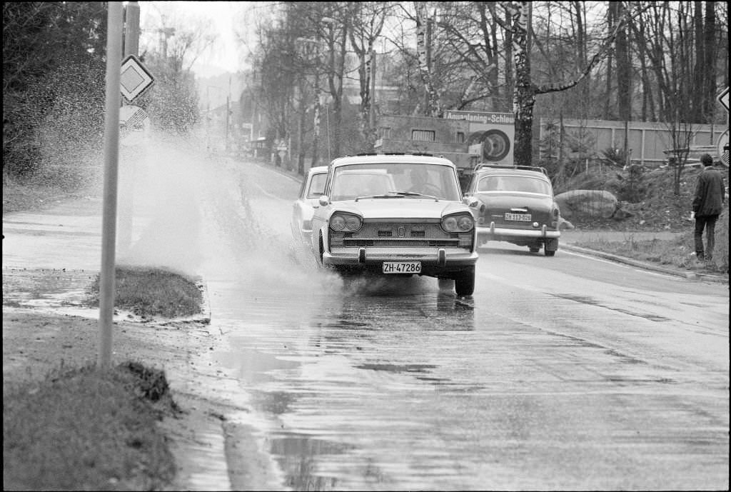 Cars driving on a wet street in Zurich, 1970