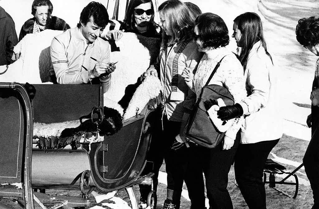 Tony Renis signing autographs for a group of fans, St. Moritz, 1970