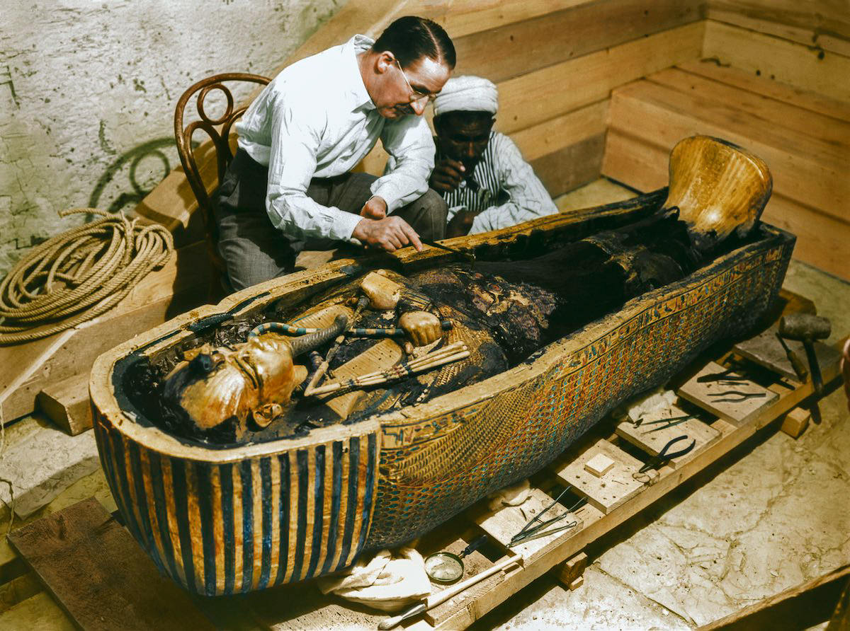 Carter and an Egyptian workman examine the third (innermost) coffin (Carter no. 255) made of solid gold, inside the case of the second coffin. Tutankhamun's Tomb, 30th October 1925