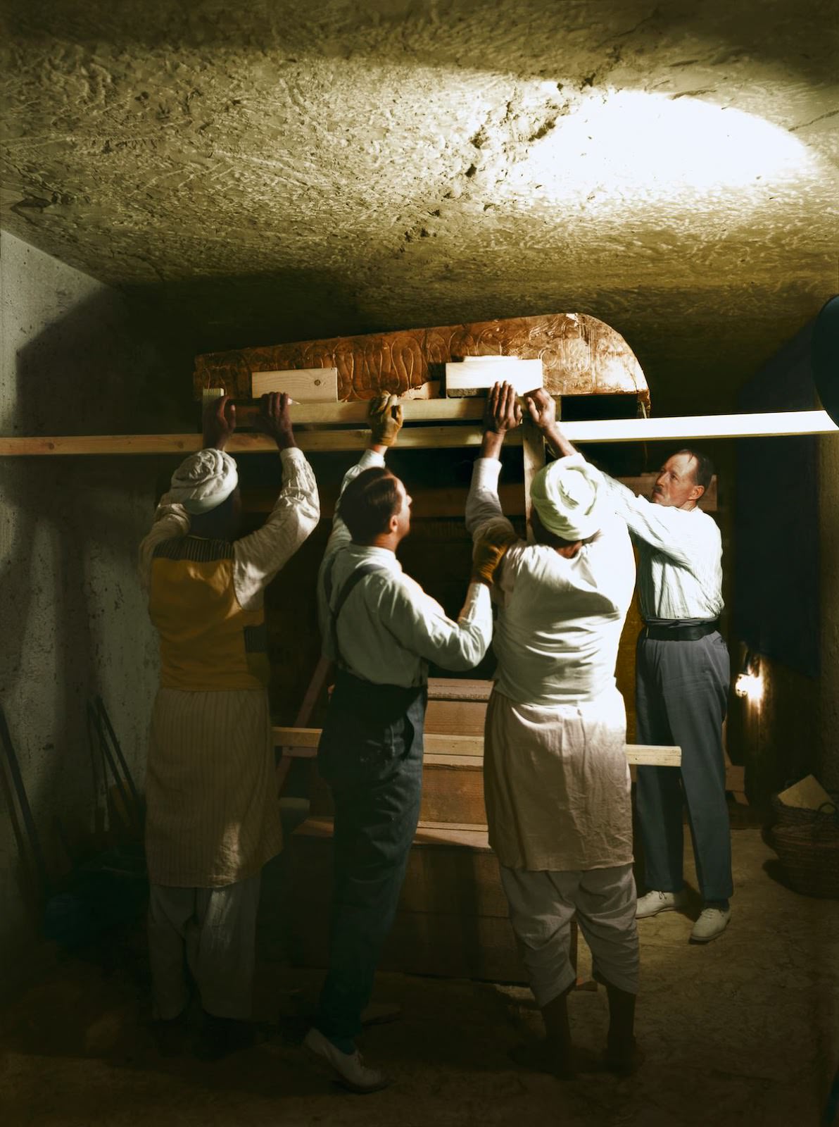 Howard Carter (centre), Arthur Callender and two Egyptian workmen lifting one roof section from the first, outermost shrine (Carter no. 207). Tutankhamun's Tomb, December 1923