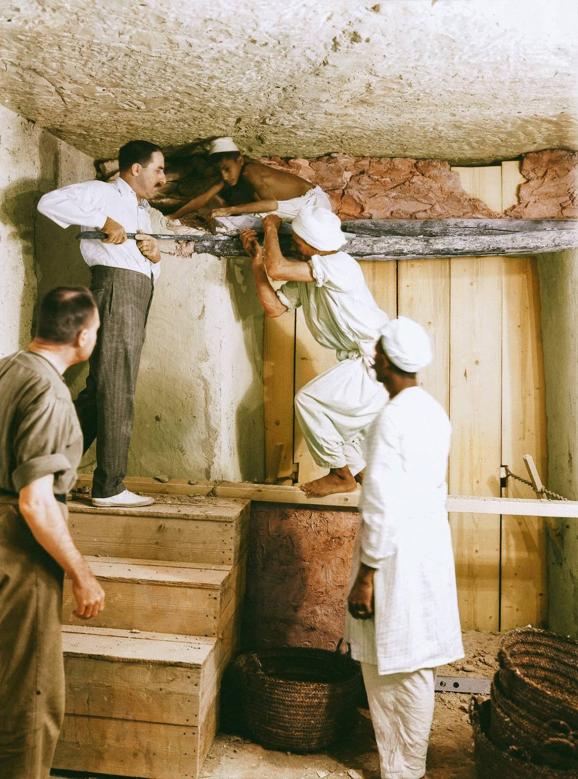 Howard Carter (at the top of the stairs), Arthur Callender and Egyptian workmen removing the wall between the Antechamber and the Burial Chamber to enable the dismantling of the four golden shrines enclosing the sarcophagus. Tutankhamun's Tomb, 2nd December 1923