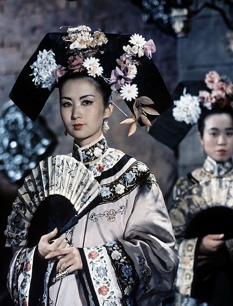 A woman fans herself in a scene from the film '55 Days At Peking', 1963.