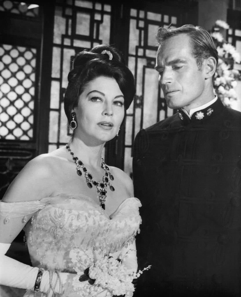 Ava Gardner is escorted by Charlton Heston in a scene from the film '55 Days At Peking', 1963.