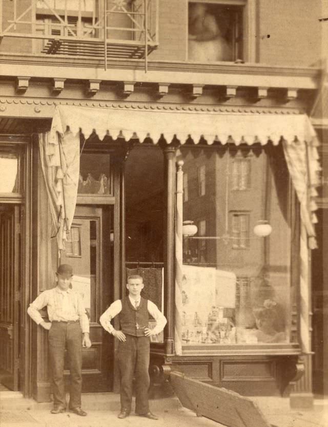 Two men outside storefront, 2336 Broadway, New York, 1880s