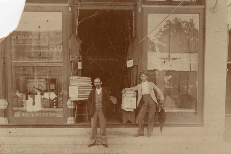 Two men outside haberdashery, 1890s