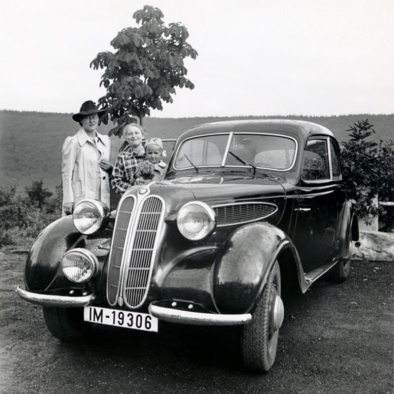 Three members of a German middle-class family posing with a BMW 321 in the countryside, 1939.