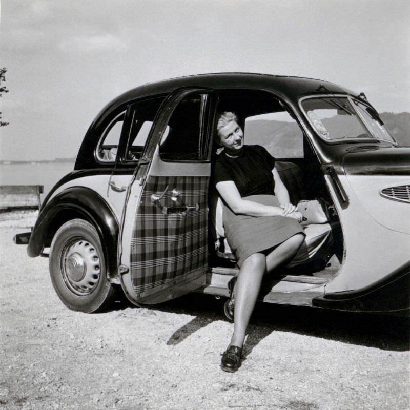 A blonde lady posing in the passenger seat of a pre-war BMW 326, 1950