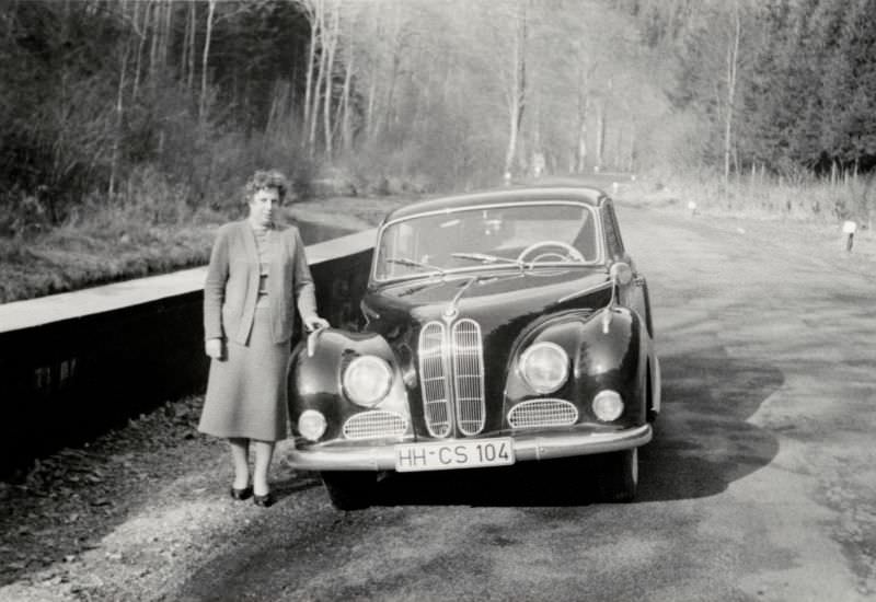 A lady posing with an eight-cylinder BMW 502 on a country road in early spring, 1958.