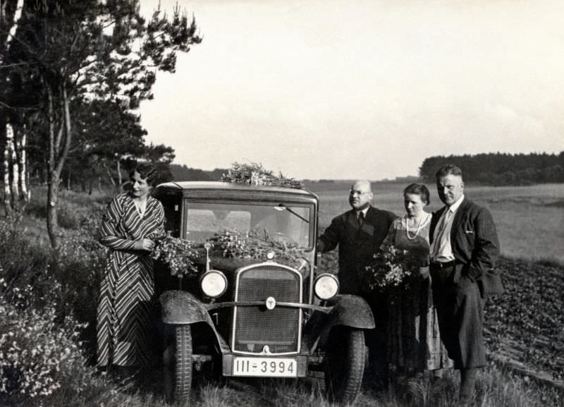 Four members of a German middle-class family posing with a BMW 3/20 PS in the countryside, 1935.