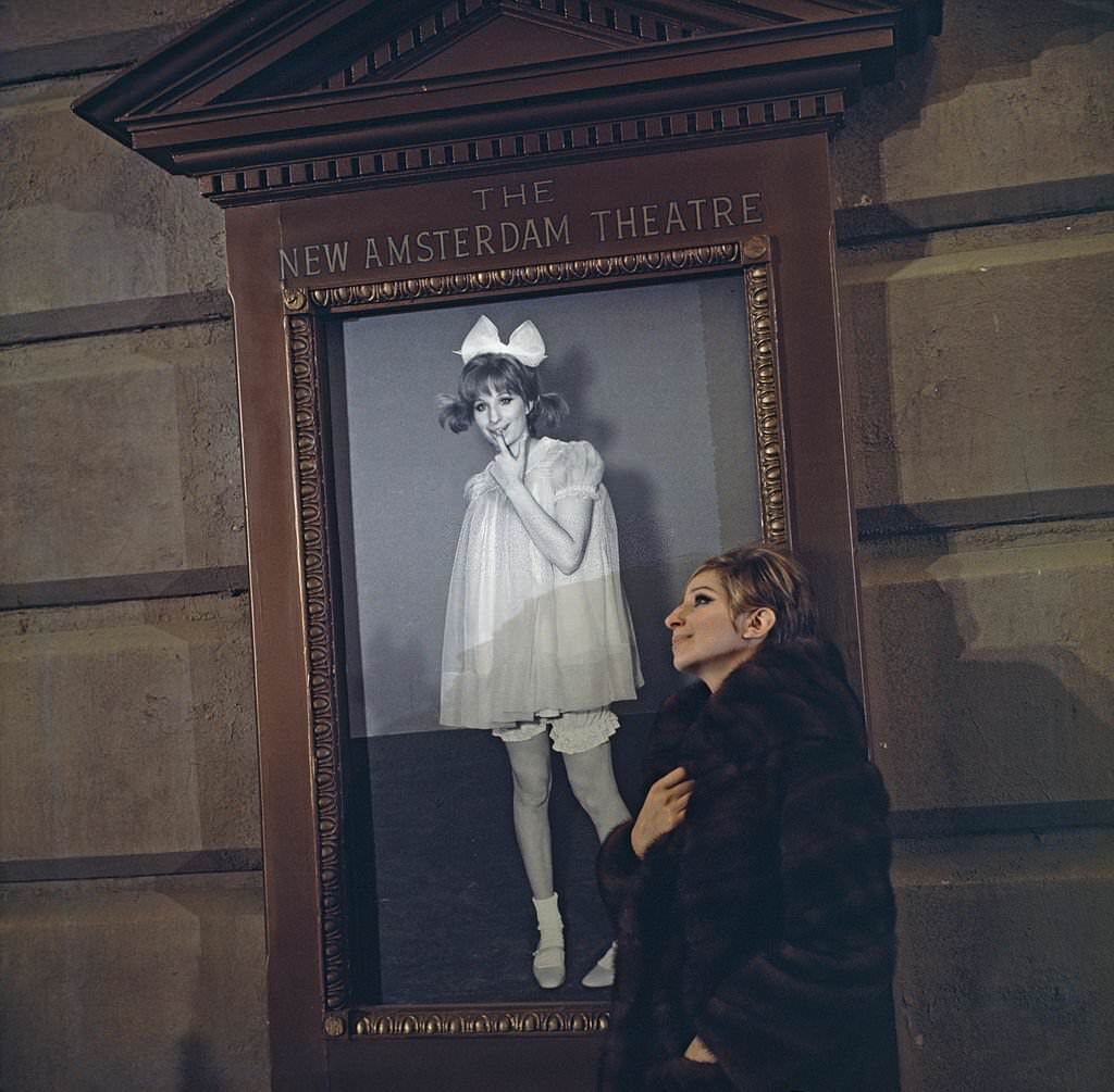 Barbra Streisand outside the New Amsterdam Theatre, New York, with a poster of herself in the movie 'Funny Girl', 1968.