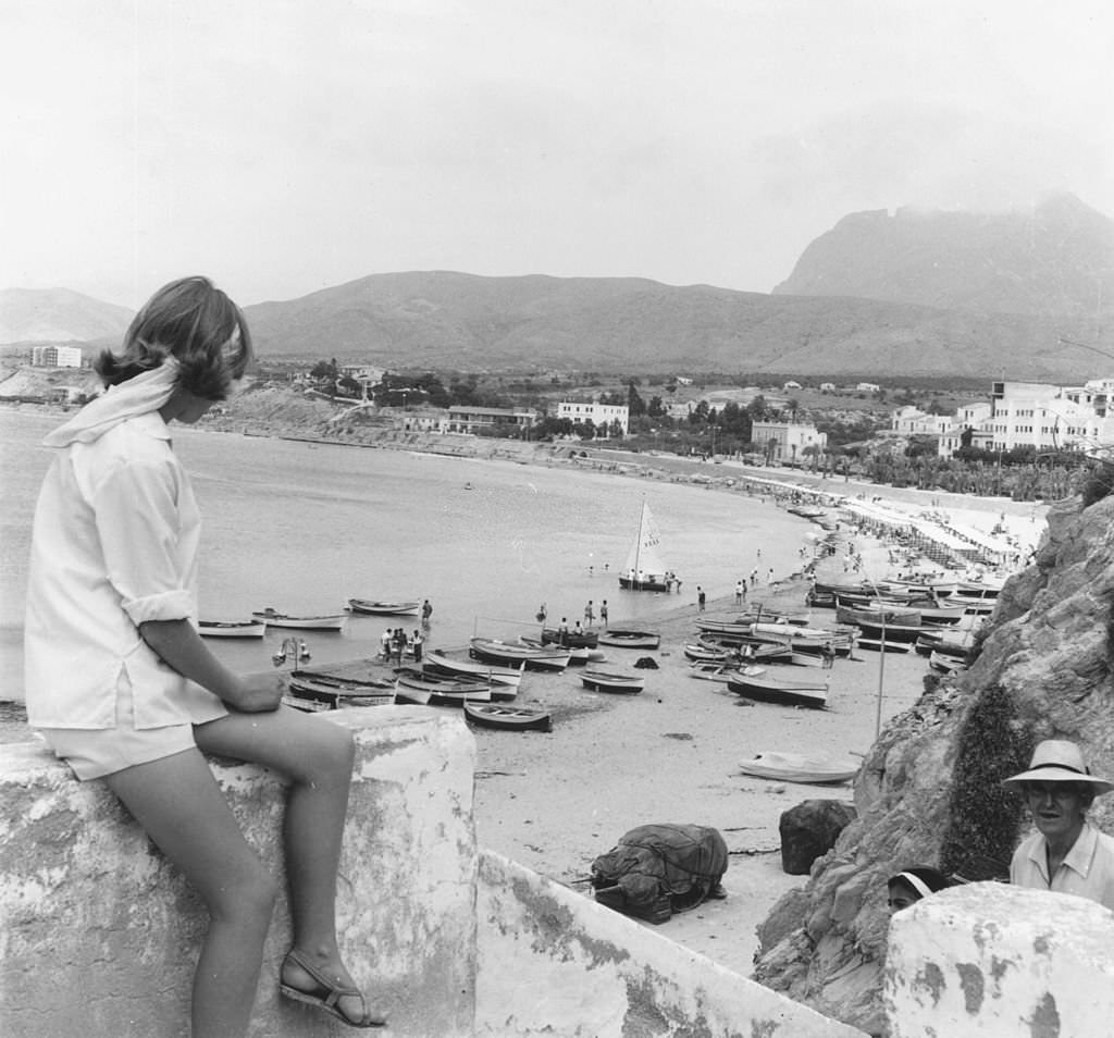 A tourist admiring the view over the beach at Benidorm, July, 1963