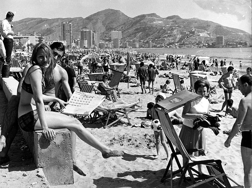 A general view of a continental beach scene, with many people sunbathing, Benidorm, Spain, 1960s