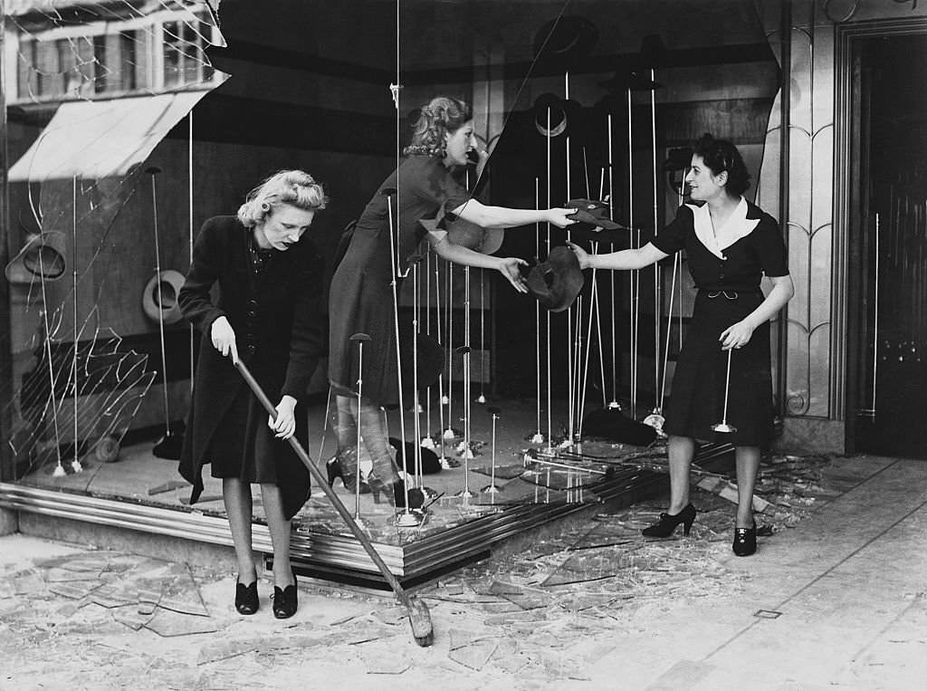 Store clerks recover hats from a display window at a fashionable shop in the center of London.