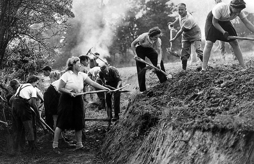 A "Ditching" party of Women of the Volunteer Land Corps at work digging a deep drainage ditch in the fields at Cheshunt