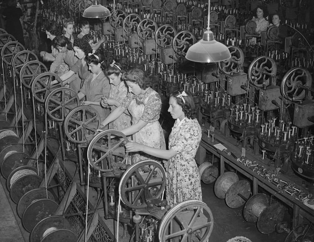 The seven Mills sisters work side by side at a munitions factory in Enfield during World War II. From left to right, they are Kitty, Beryl, Irene, Marjorie, Doris, Phyllis and Violet, 1942