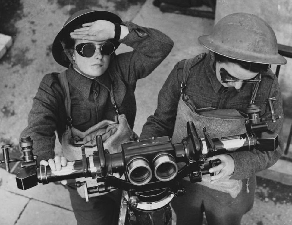Women in the Army Transport Service working as artillery spotters adjust a range finder.