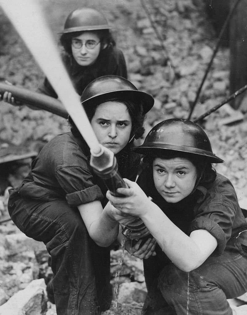 A team of firewomen belonging to the Royal Northern Hospital in Holloway, train their hose on an imaginary fire during practice for Blitz fires.