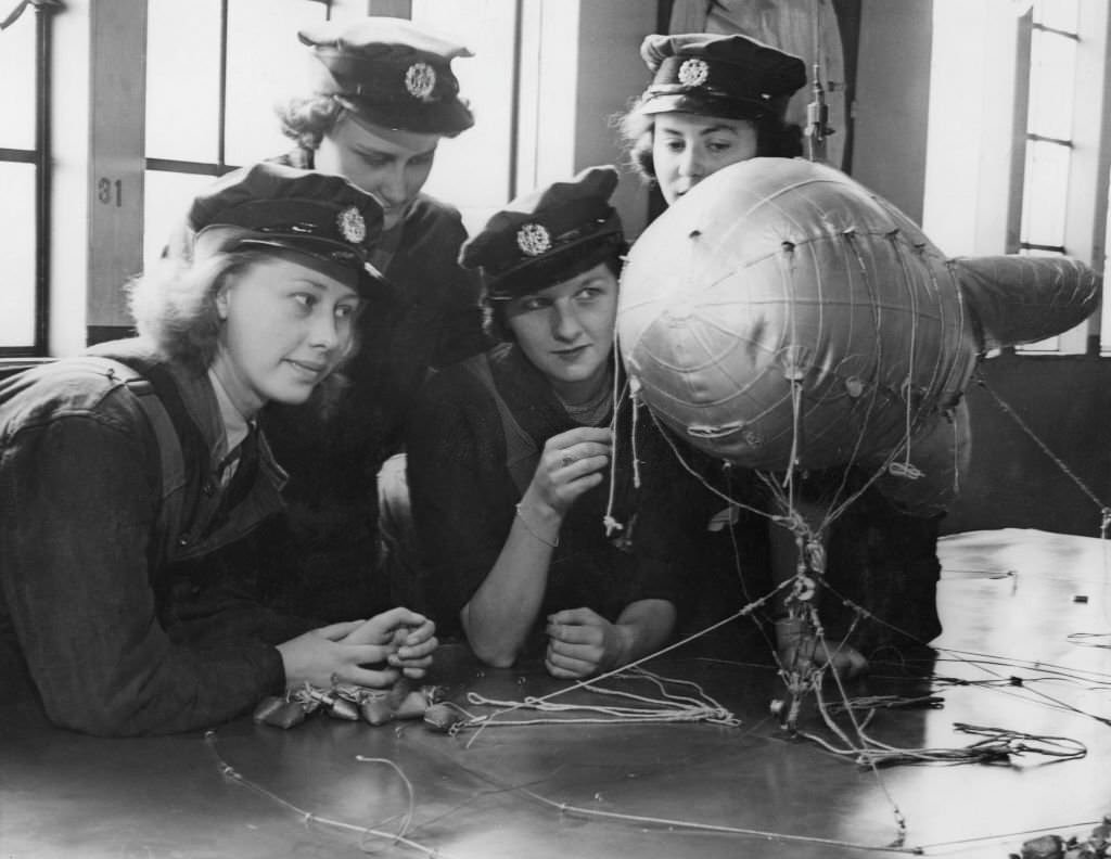 Members of the Women's Auxiliary Air Force (WAAF) using a model to study the construction of barrage balloons, UK, 11th September 1941.