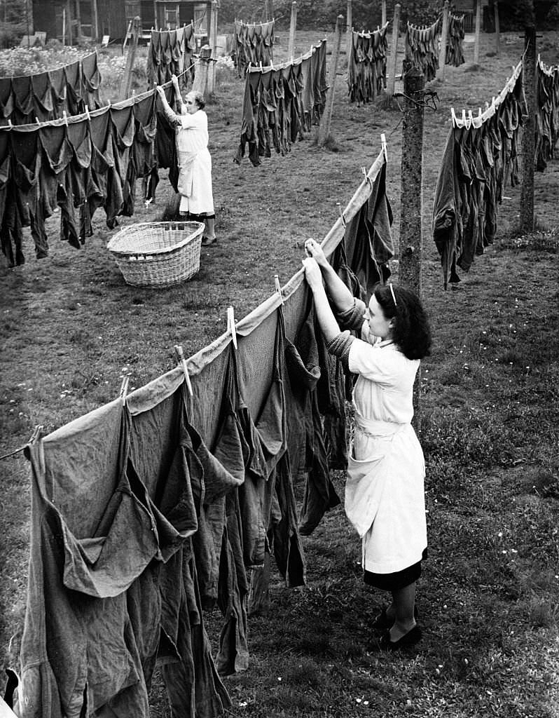 Women hang out army shirts at a laundry in Surrey, England in 1941.